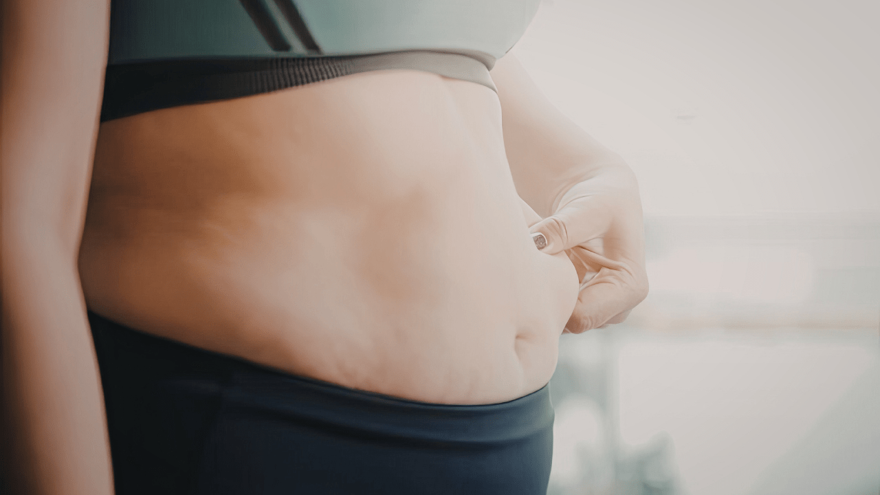 Woman Pinching Belly Fat - Coach Chris Nutritionist & Weight Loss Coach 